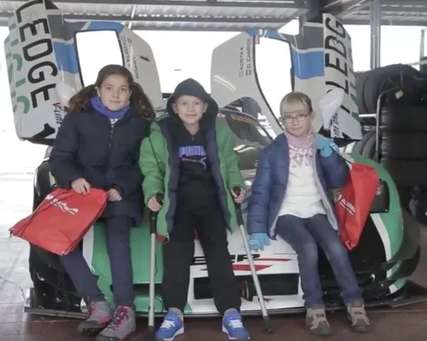 Niños sentados en un coche de competición
